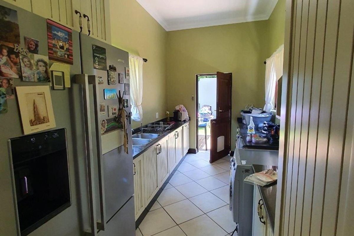 A functional kitchen featuring built-in cabinetry, tiled flooring, and direct access to the exterior.