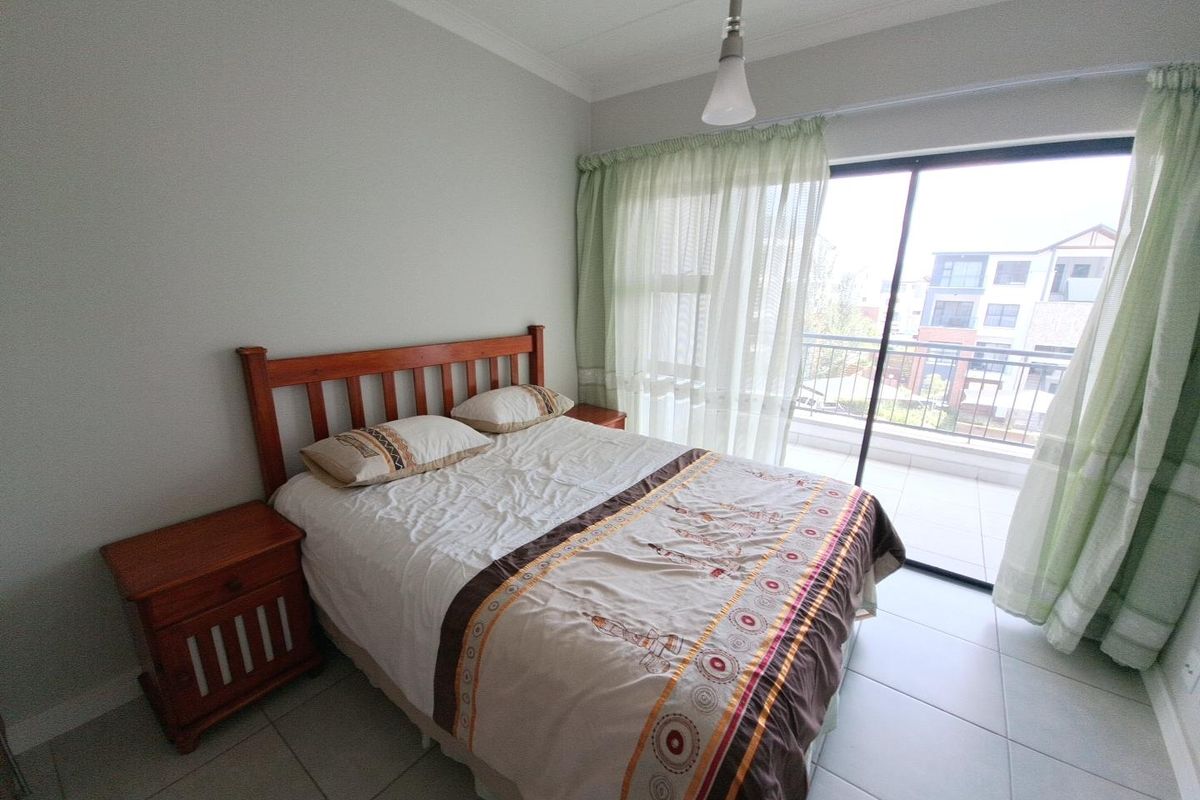 A bedroom featuring tiled flooring and a sliding glass door providing direct access to a private balcony.