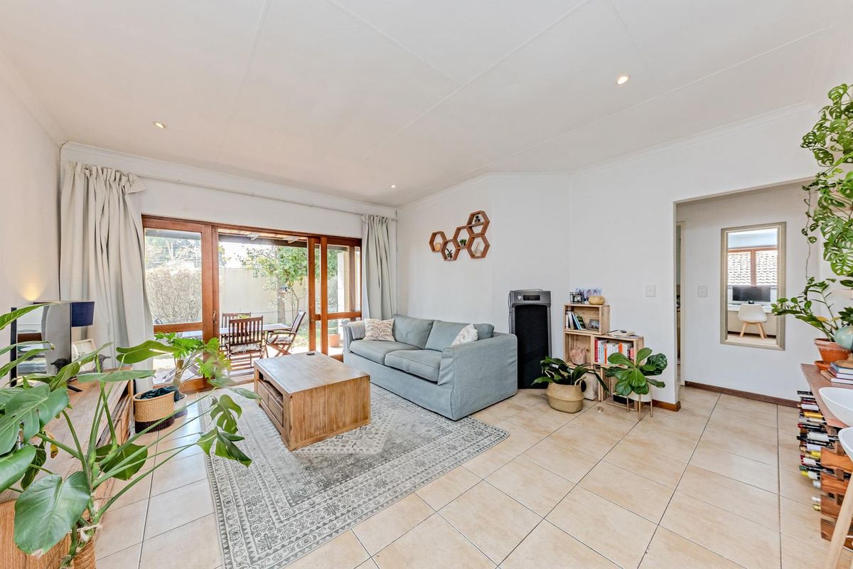 Bright living room featuring tiled flooring and large sliding glass doors that provide seamless access to the outdoor patio area.