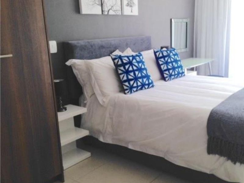 A well-maintained bedroom featuring tiled flooring and a built-in wardrobe, offering a clean and functional living space.