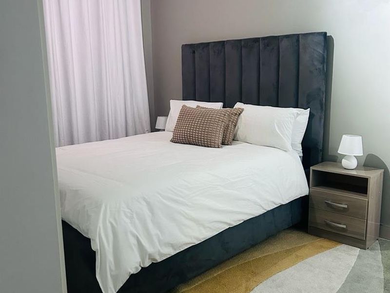 A well-maintained bedroom featuring neutral wall tones and a functional layout, providing a comfortable and inviting sleeping space.