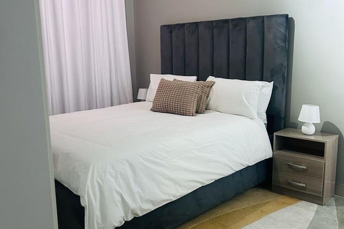 A well-maintained bedroom featuring neutral wall tones and a functional layout, providing a comfortable and inviting sleeping space.