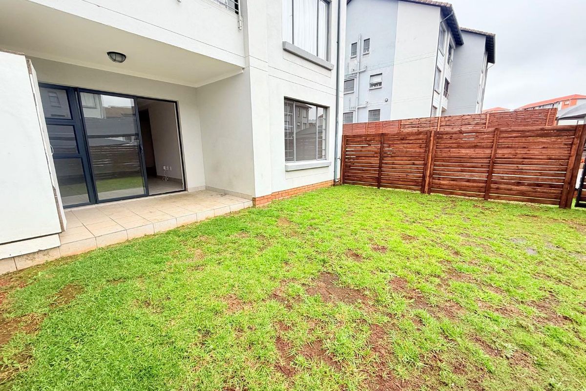 Private rear garden featuring a paved patio area, sliding glass door access, and timber perimeter fencing.