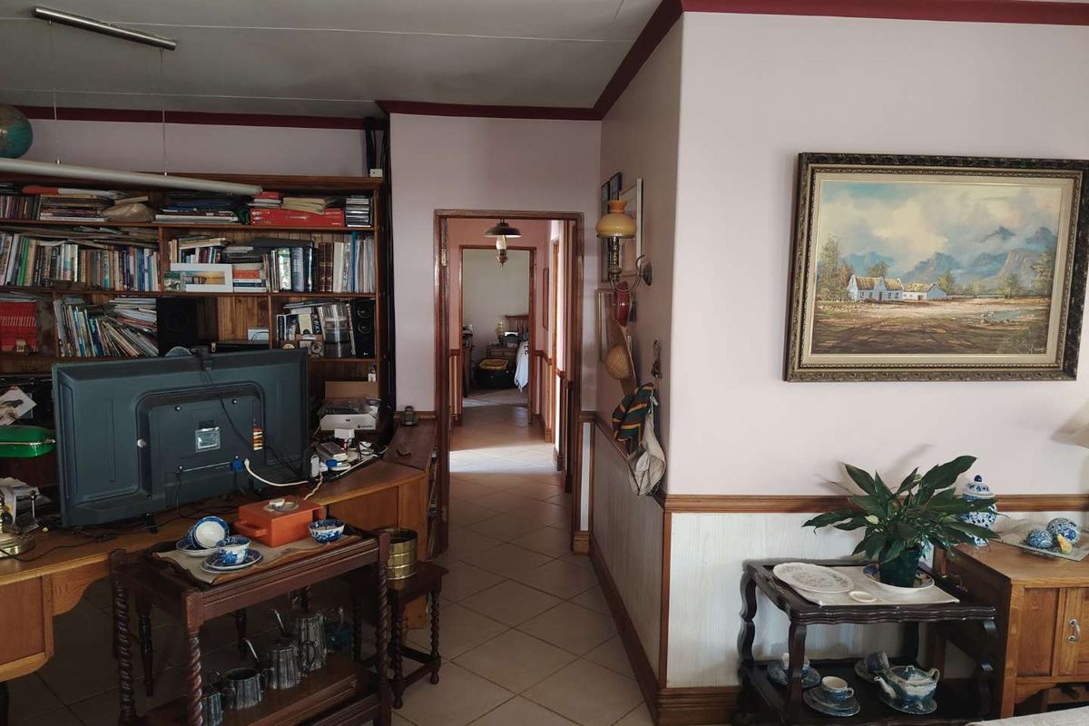 A view from the living area looking into a central hallway with tiled flooring and traditional wall paneling.