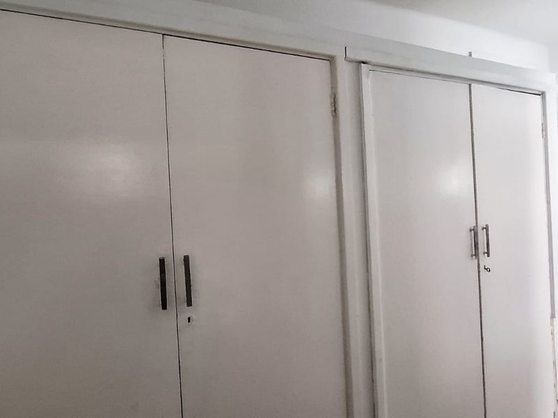 A functional hallway area featuring built-in storage cupboards and tiled flooring, providing practical storage space within the property.