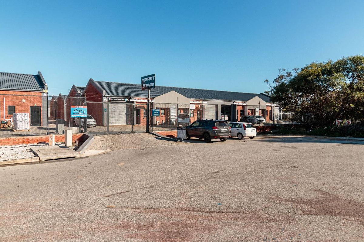 Front view of Moffett Park commercial property featuring brick facade, metal roofing, secure gated access, and paved parking area.