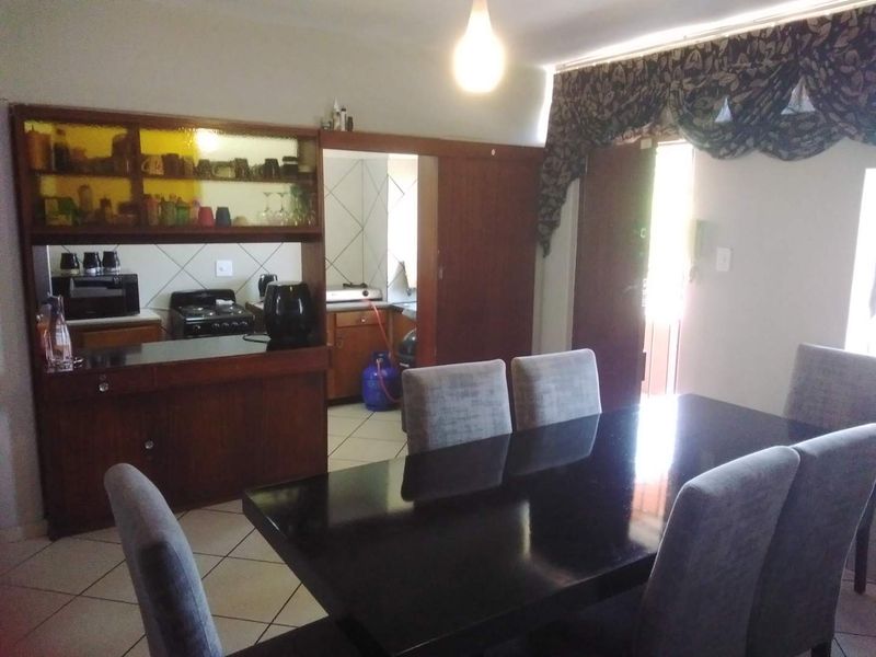 Open plan dining area featuring tiled flooring and direct access to a kitchen with built-in cabinetry and a gas stove.