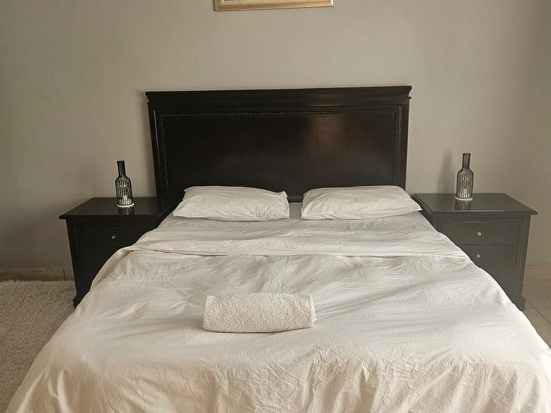 A well-maintained bedroom featuring neutral wall tones and tiled flooring, providing a clean and functional space.