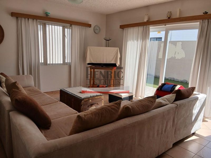 A living room featuring tiled flooring and sliding glass doors that provide access to an outdoor area.