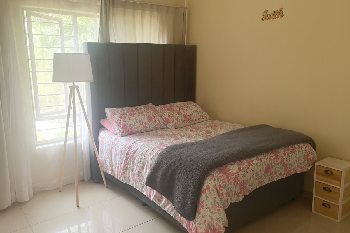 A bedroom featuring tiled flooring and a large window with security bars, providing natural light.