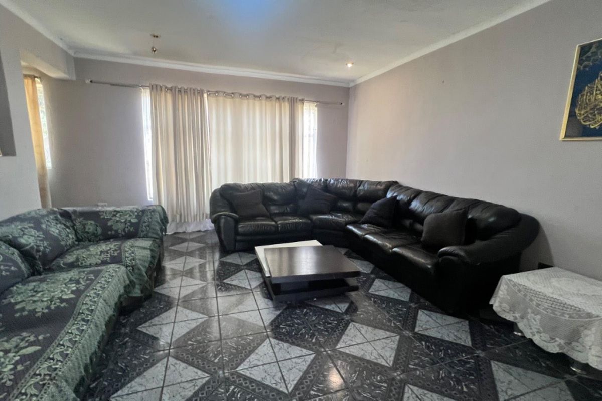 Spacious living room featuring patterned tiled flooring and neutral wall tones, providing a comfortable area for relaxation and family gatherings.