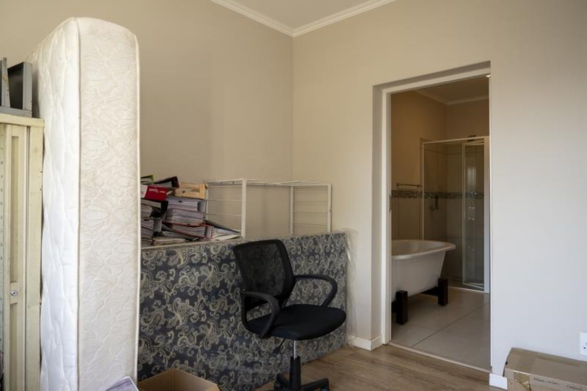 A view from a room looking into an en-suite bathroom featuring a freestanding bathtub and a glass-enclosed shower.