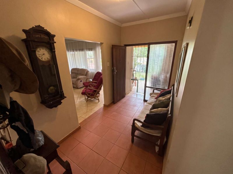 Entrance hall featuring tiled flooring and a sliding glass door with security gate, providing access to the main living area.