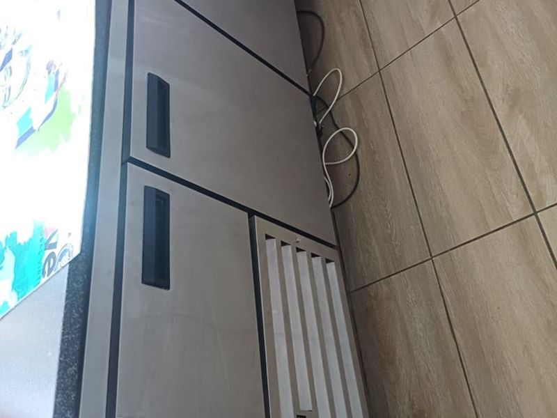 A commercial-grade under-counter refrigerator unit installed in a tiled kitchen area.