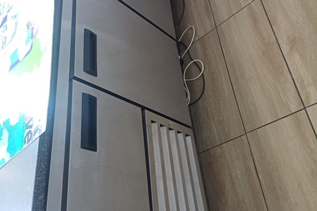 A commercial-grade under-counter refrigerator unit installed in a tiled kitchen area.