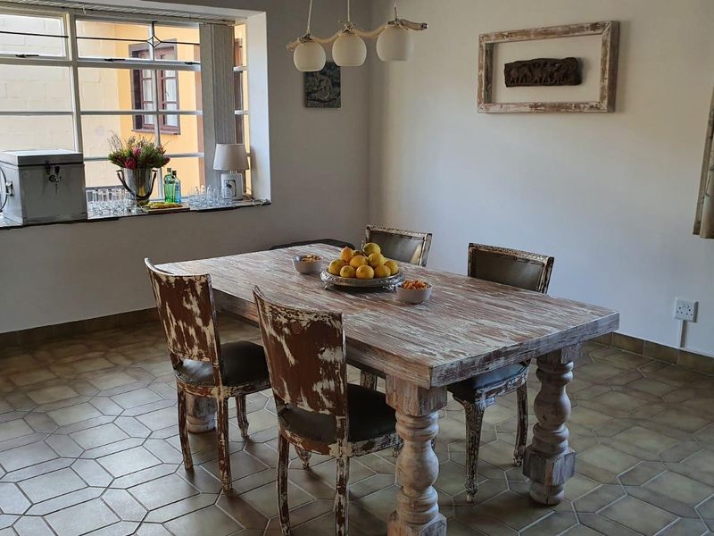 A dining room featuring tiled flooring, a large multi-pane window providing natural light, and a central pendant light fixture.