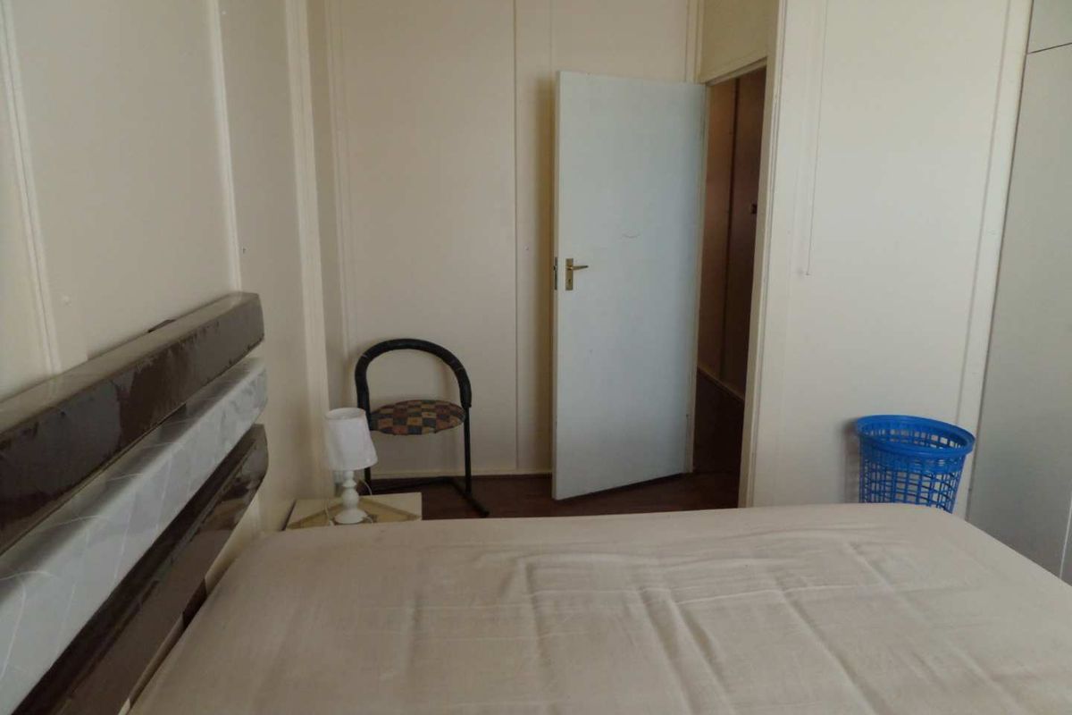 A simple bedroom featuring neutral walls and a standard door, providing a functional and basic living space.