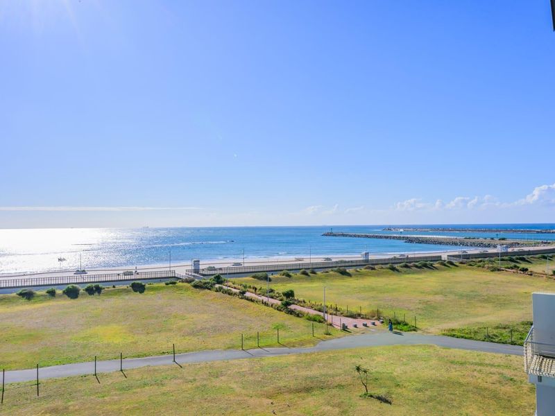 A clear, elevated view overlooking the coastal landscape, beach, and ocean horizon from the apartment.