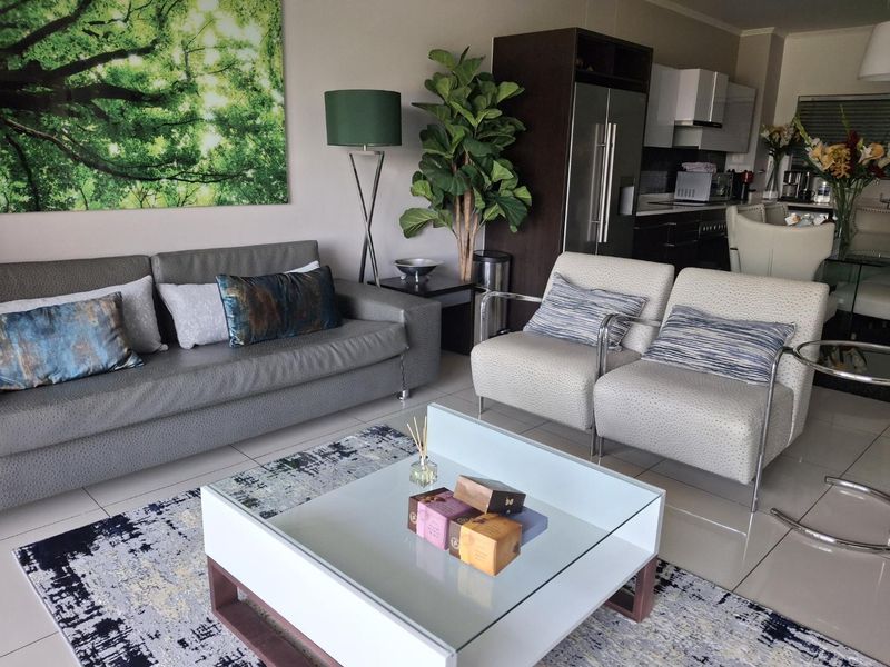 An open-plan living and kitchen area featuring tiled flooring and modern cabinetry, creating a cohesive and functional space for daily living.