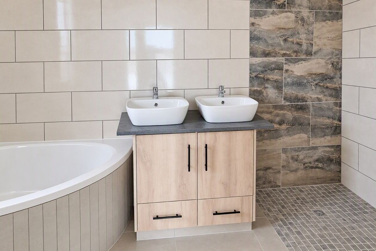 Modern bathroom featuring a double vanity with vessel sinks, a corner bathtub, and a spacious walk-in shower with contemporary tile finishes.