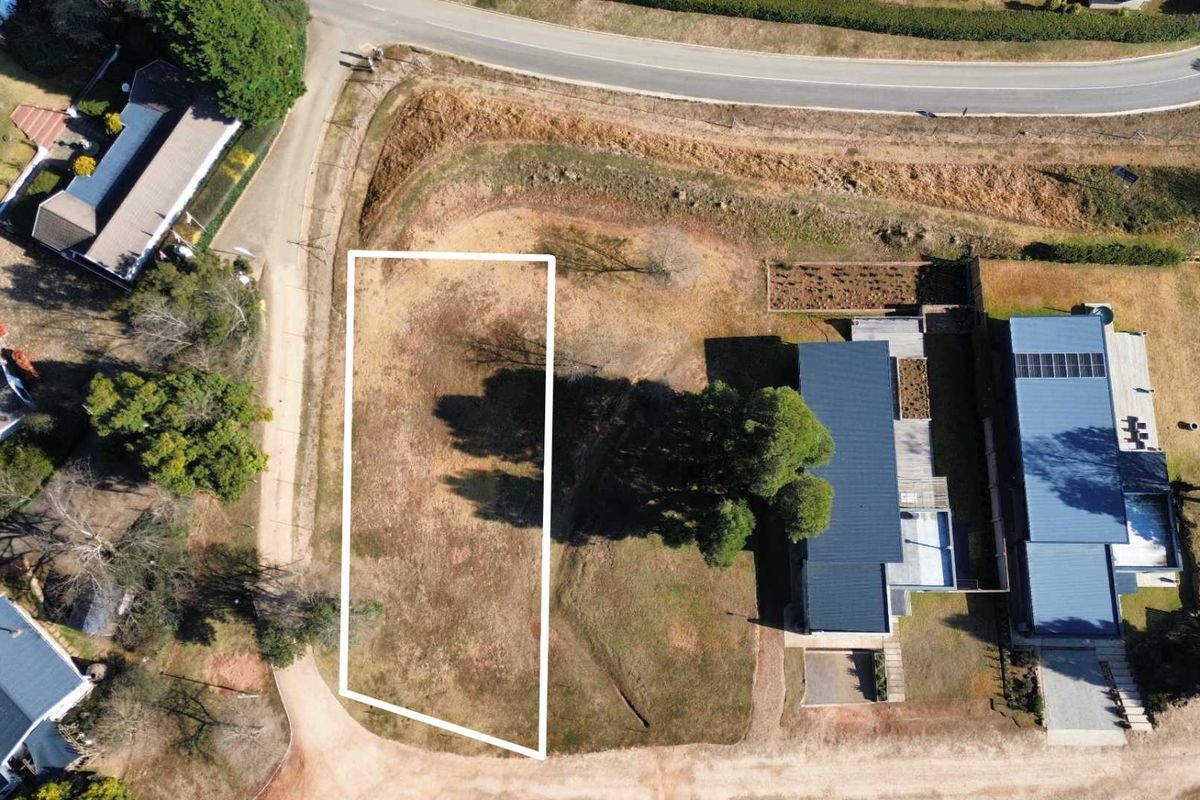 Aerial view of a vacant residential plot with clearly marked boundaries, situated in a developed neighborhood.
