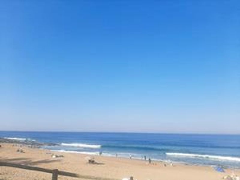 A scenic view of the ocean and sandy beach, showcasing the coastal location of the property.