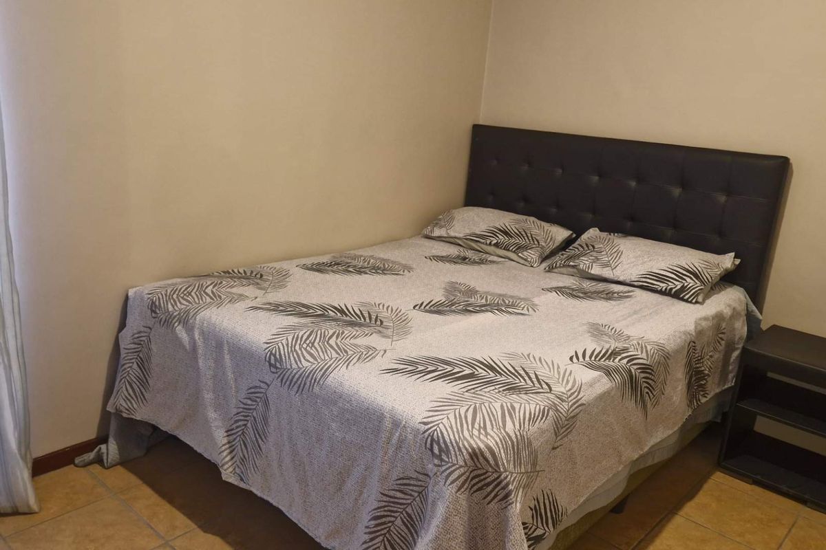 A standard bedroom featuring tiled flooring and neutral wall finishes.