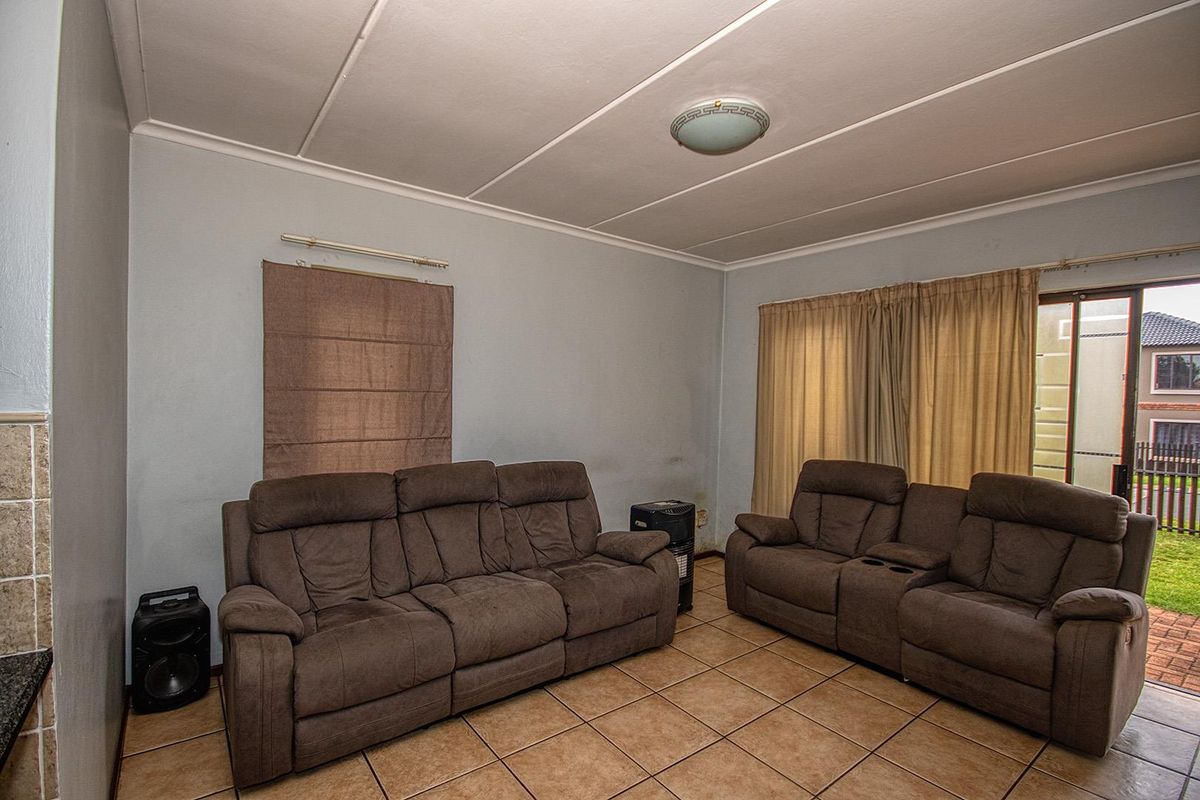 A living room featuring tiled flooring and a sliding glass door providing access to the outdoor area.