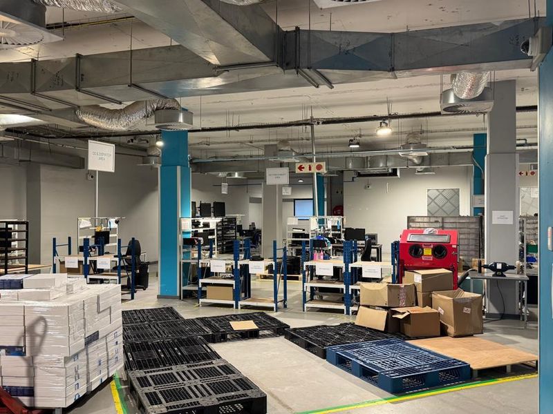 Spacious industrial warehouse or workshop area featuring exposed ceiling ducting, concrete flooring, and functional open-plan layout suitable for logistics or manufacturing operations.