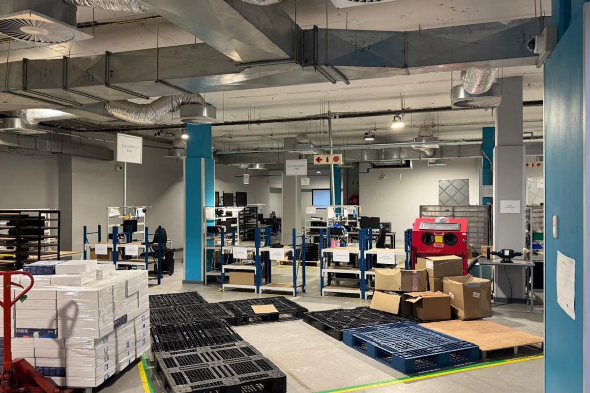 Spacious industrial warehouse or workshop area featuring exposed ceiling ducting, concrete flooring, and functional open-plan layout suitable for logistics or manufacturing operations.