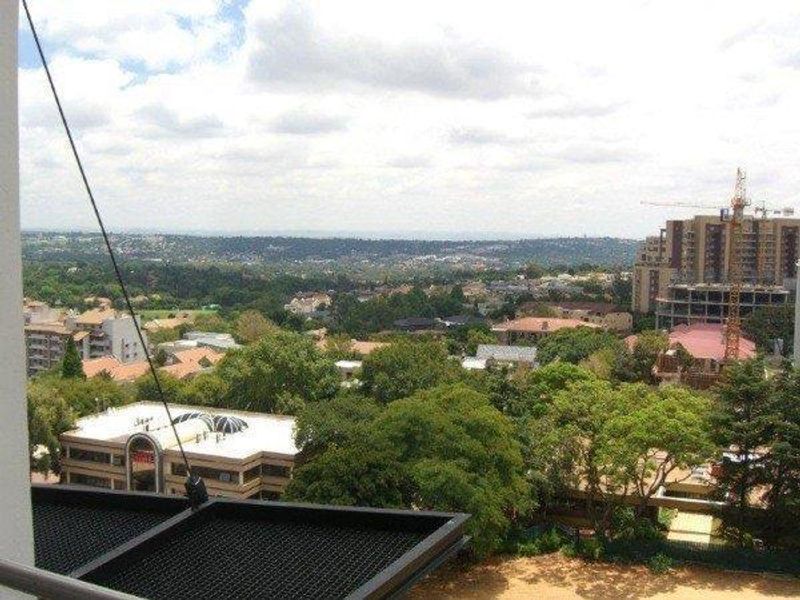 An elevated panoramic view overlooking the surrounding suburban landscape, trees, and neighboring apartment developments.