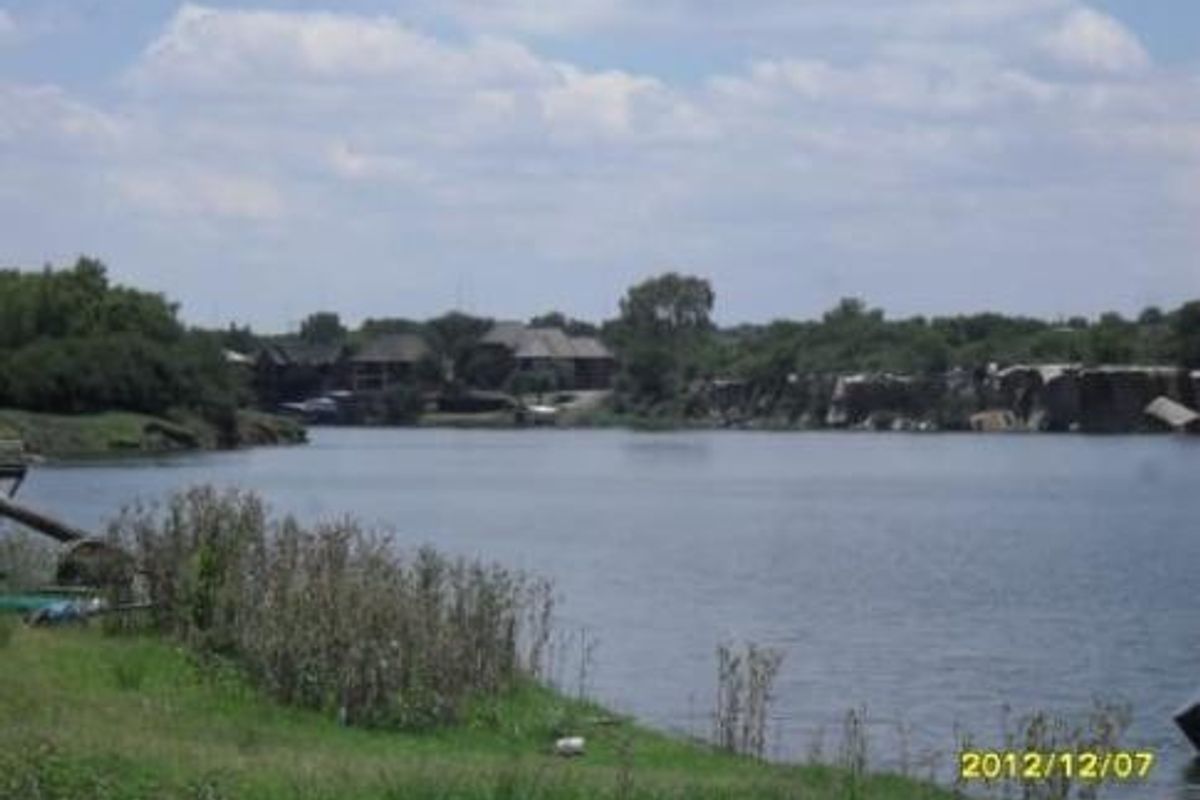 A scenic view of a lake and surrounding landscape, capturing the natural waterfront setting of the property.