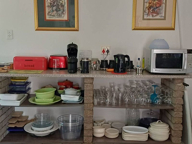 A kitchen area featuring a custom brick-based island with laminate countertop and open shelving for storage.