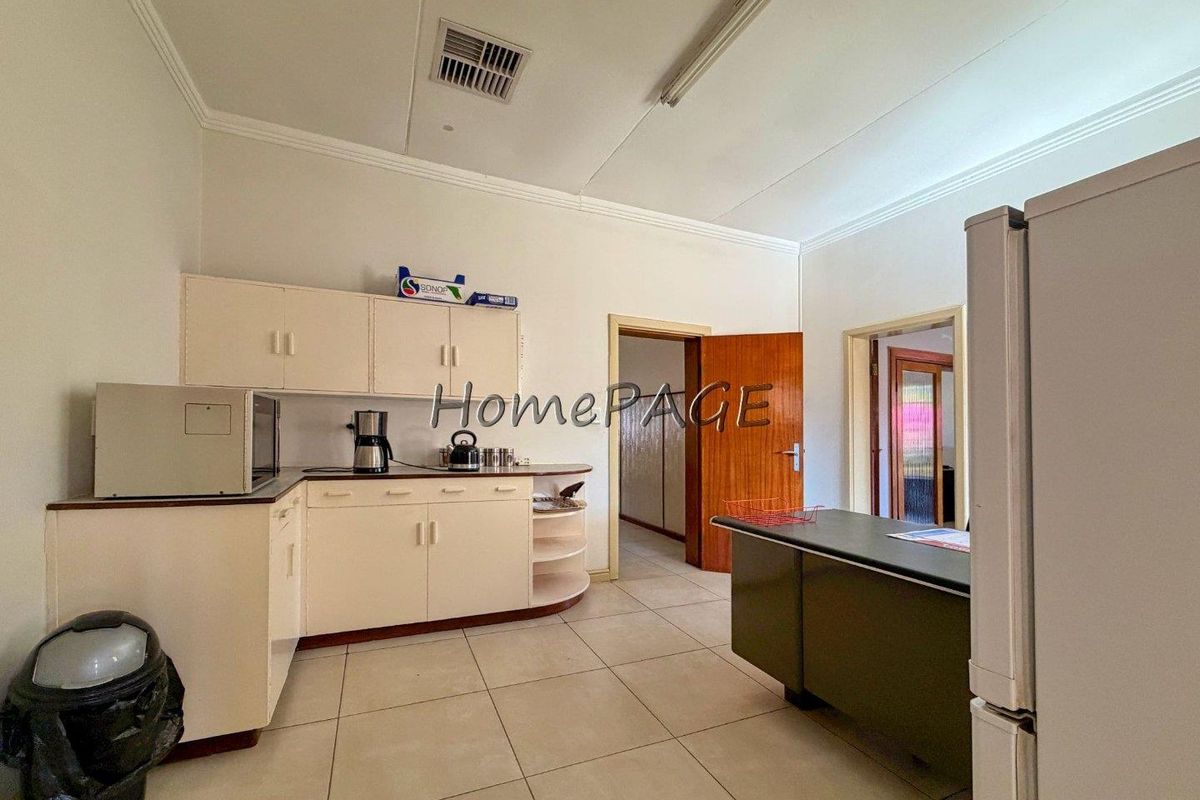 A functional kitchen featuring dated built-in cabinetry, tiled flooring, and a central air vent, offering potential for a modern renovation.