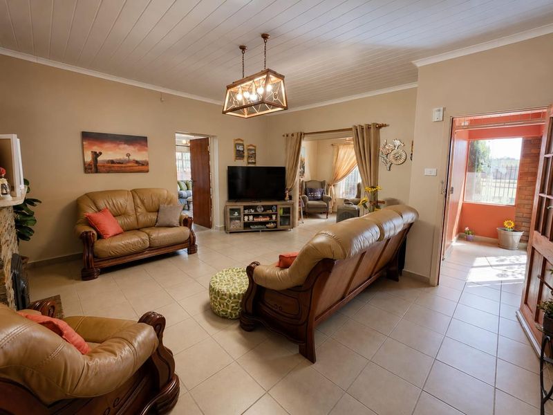 Spacious living room featuring tiled flooring, a tongue and groove ceiling, and a stone fireplace surround, offering a comfortable and functional layout.