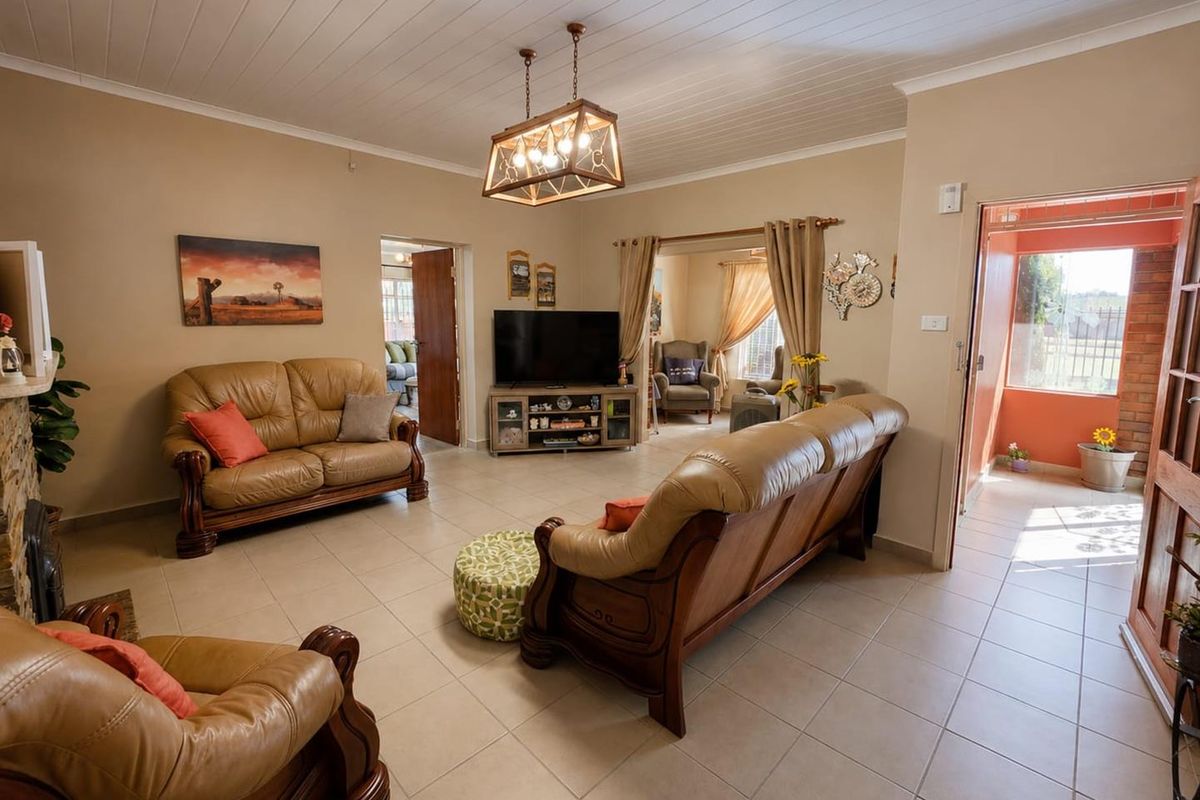 Spacious living room featuring tiled flooring, a tongue and groove ceiling, and a stone fireplace surround, offering a comfortable and functional layout.