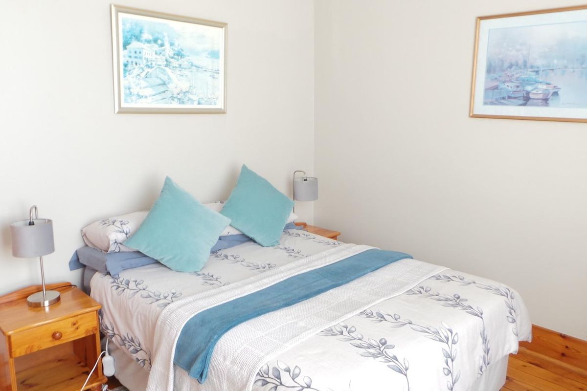 A cozy bedroom featuring warm timber flooring and neutral wall finishes, providing a comfortable and inviting sleeping space.