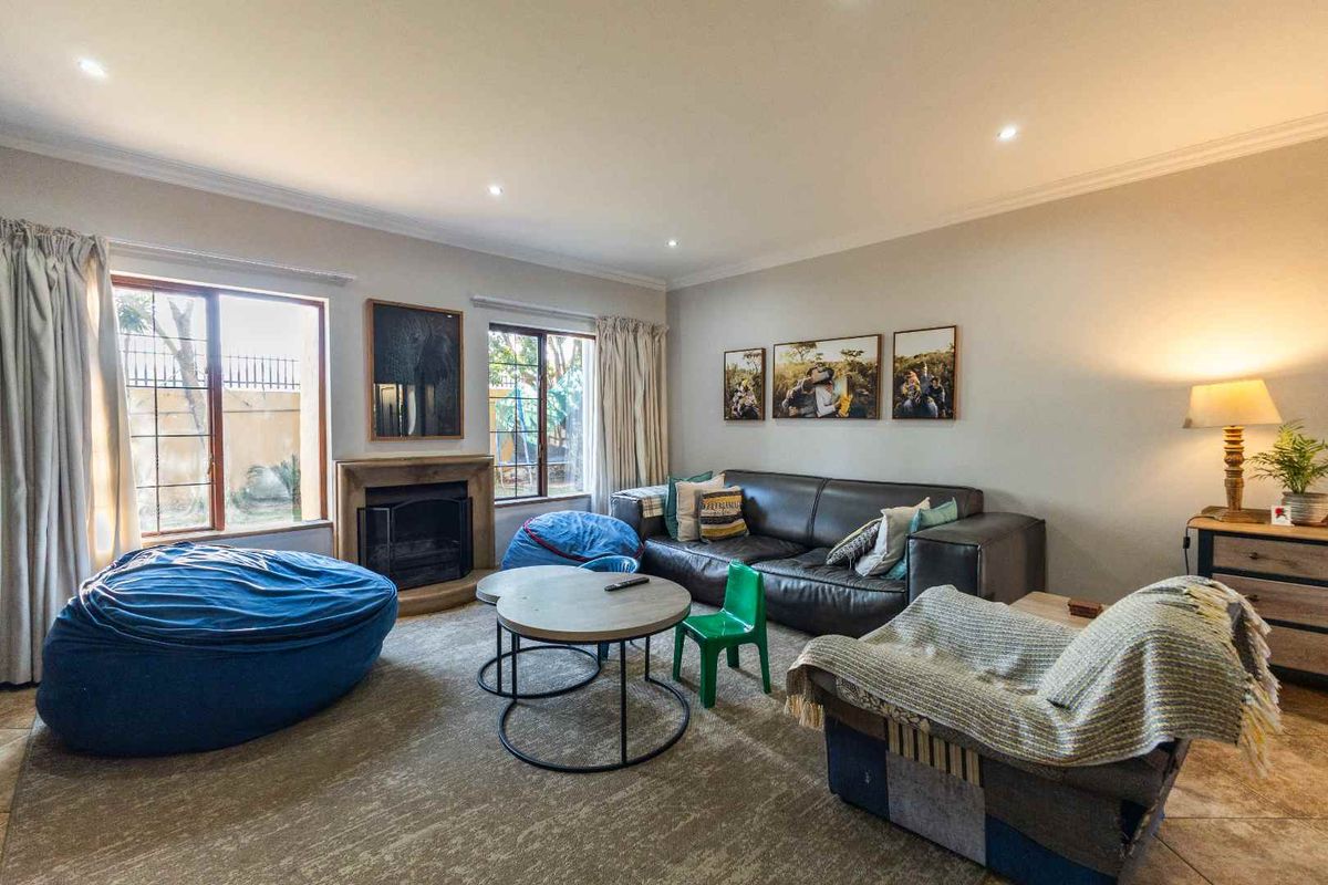 A comfortable living room featuring a built-in fireplace, tiled flooring, and recessed downlighting, offering a warm and inviting space for relaxation.