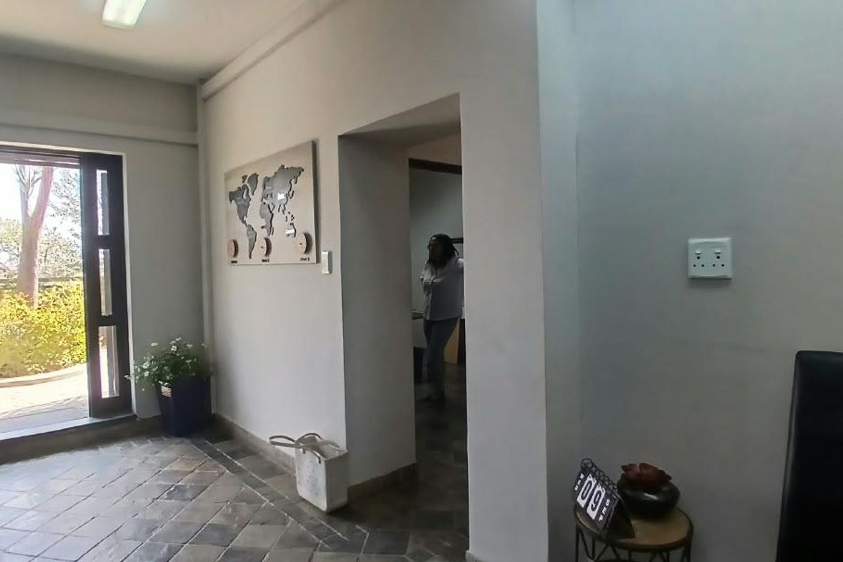 An office entrance area featuring tiled flooring, neutral walls, and direct access to an outdoor space through a glass-paneled door.