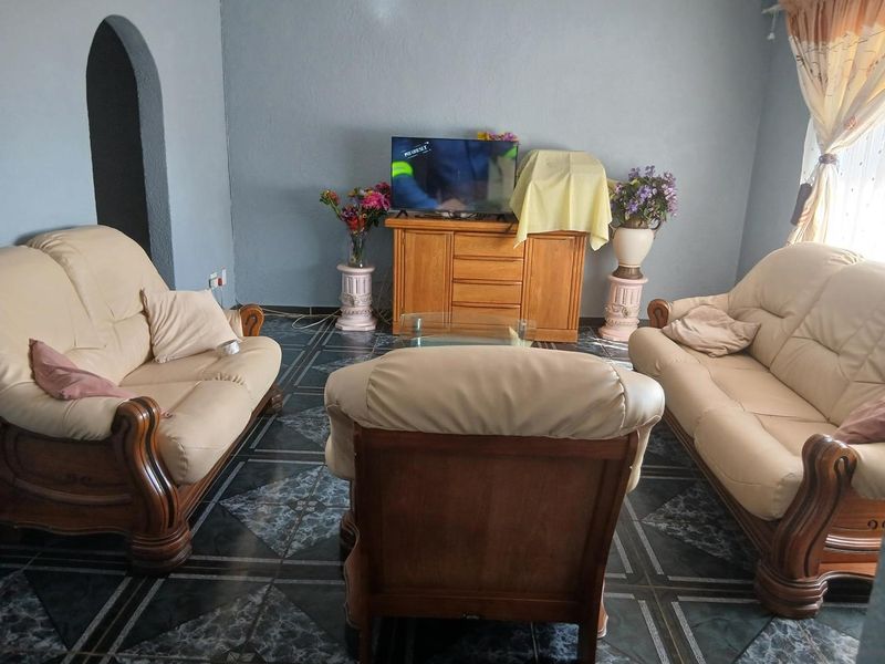 A living room featuring dark patterned floor tiles and an arched architectural detail, providing a functional space for relaxation.