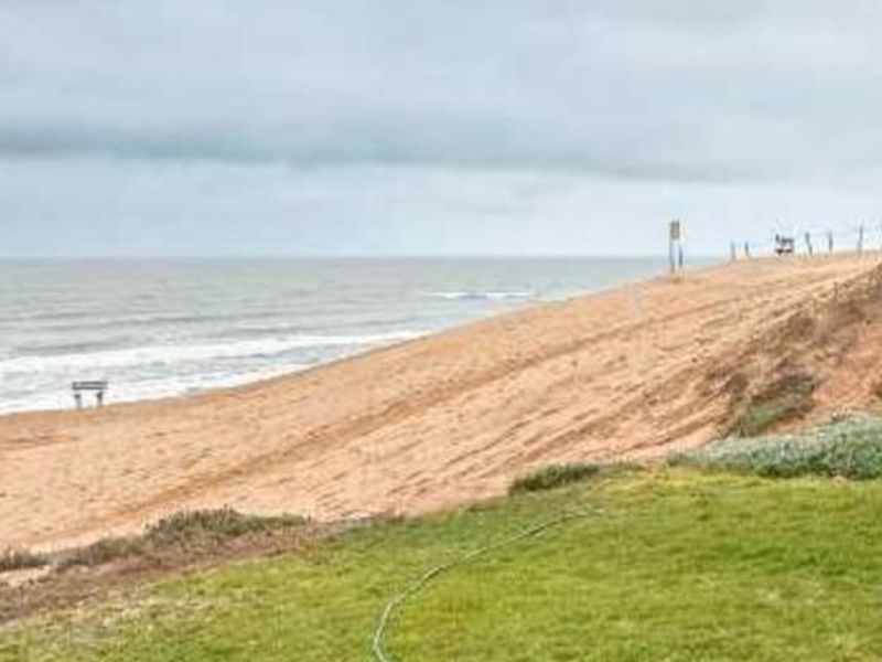 A scenic view of the coastline and beach, showcasing the natural landscape and proximity to the ocean.