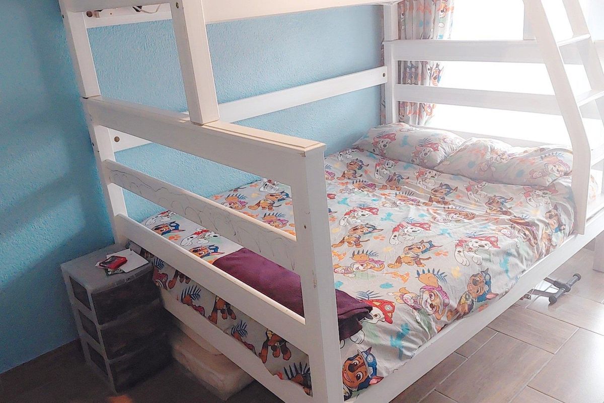 A bedroom featuring tiled flooring and natural light from a window.