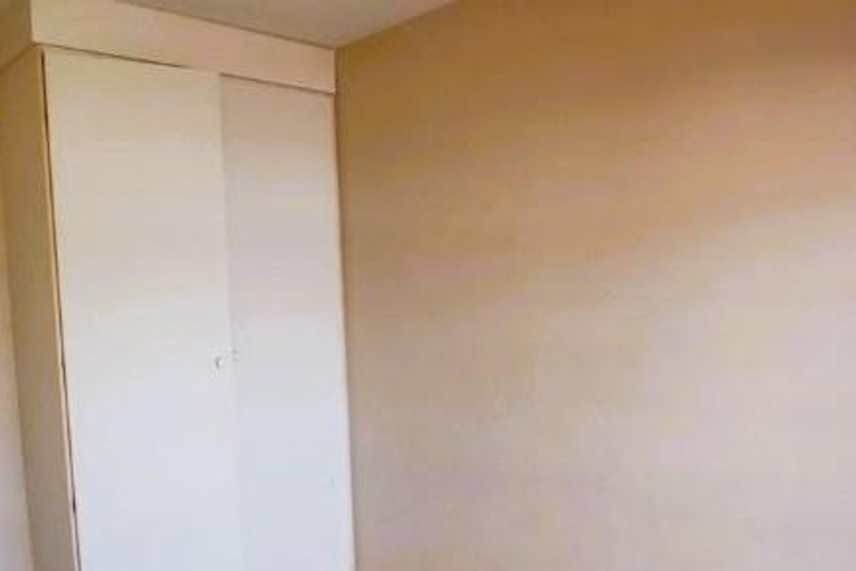 A simple bedroom featuring built-in cupboards and neutral wall finishes, offering a blank canvas for personalization.