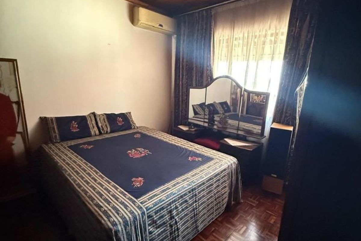 A bedroom featuring warm timber ceiling paneling, classic parquet flooring, and a wall-mounted air conditioning unit.