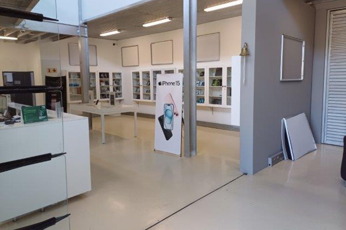 Open-plan office or retail space featuring built-in display cabinetry, industrial steel columns, and durable epoxy flooring with modern lighting.