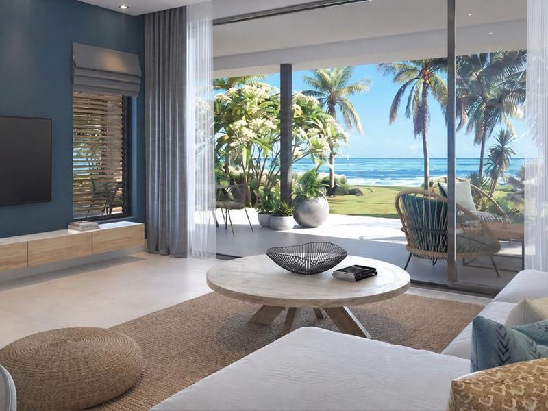 Modern living room featuring large sliding glass doors that open to a patio with scenic ocean views and integrated media console.