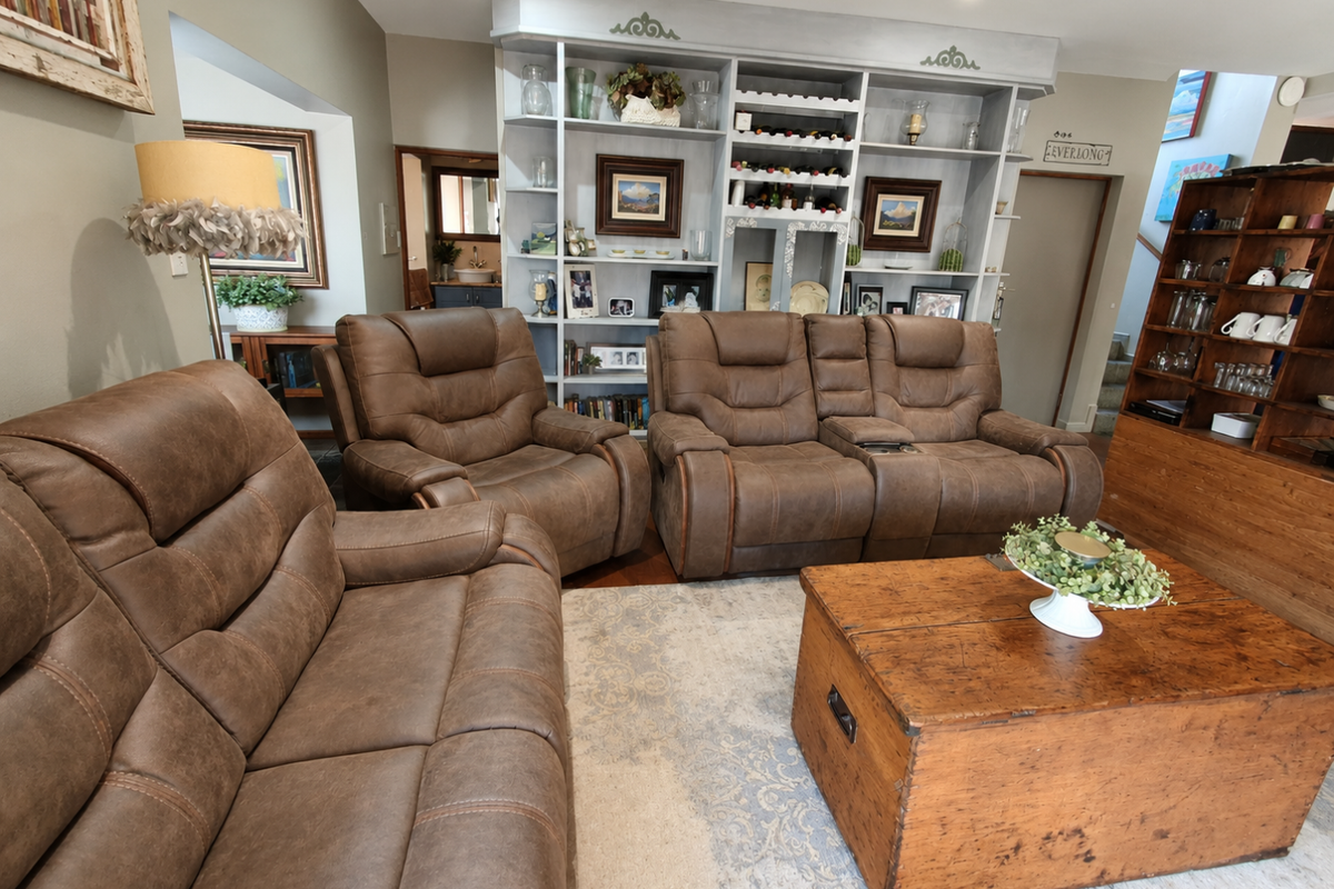 A comfortable living room featuring a large built-in shelving unit, recessed lighting, and warm hardwood flooring, creating a cozy and functional space.