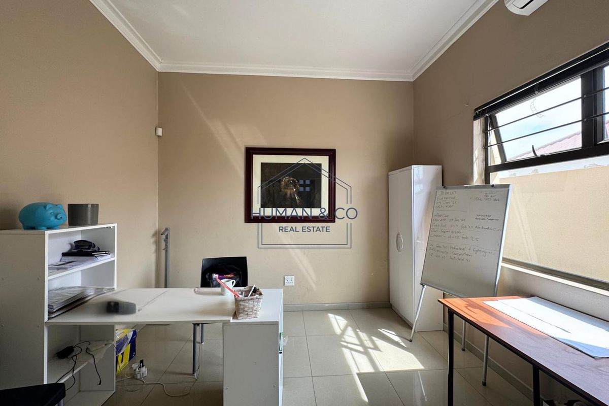 A functional office space featuring tiled flooring, coving, and an integrated air conditioning unit, providing a practical work environment.