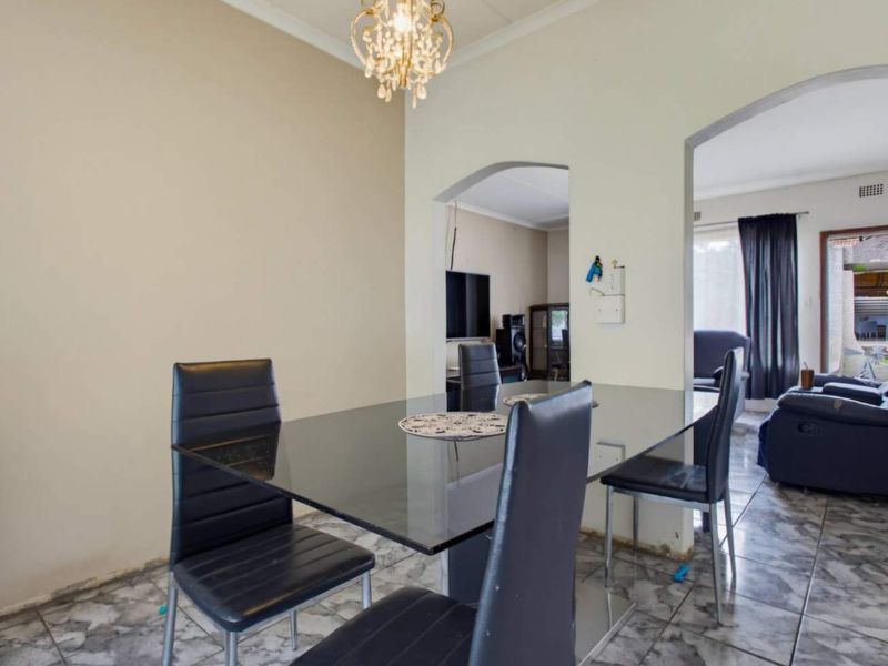 Dining area featuring tiled flooring and an open-plan layout with arched transitions to the adjacent living space.