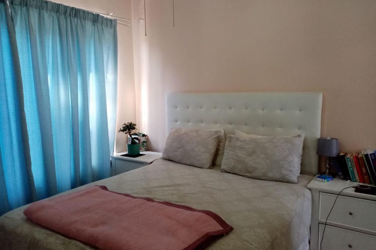A standard bedroom featuring a neutral wall finish and window with curtain rail, providing a functional sleeping space.